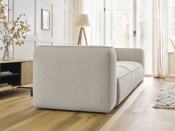 Canapé Zephyr en tissu beige clair vu de côté, montrant sa structure modulaire et ses lignes.
