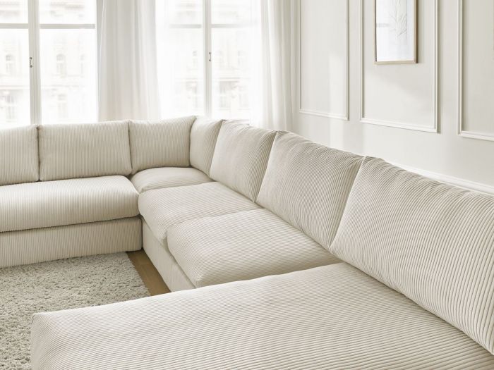 Gros plan des coussins et dossiers du canapé Paris beige.