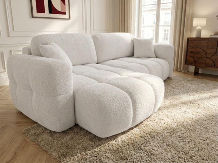 Canapé Madison blanc angle en salon avec fenêtres, commode et tapis gris.