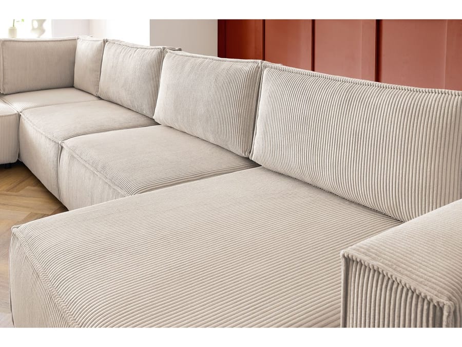 Gros plan des coussinets et de la matière striée du canapé Nihad en beige.
