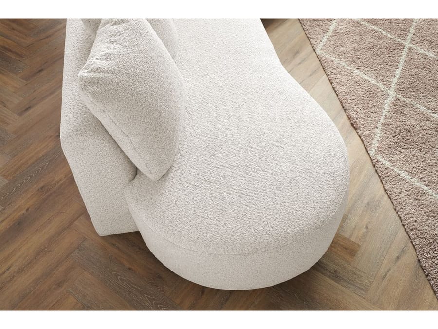 Gros plan du pied arrondi et du revêtement beige clair du canapé Marianne