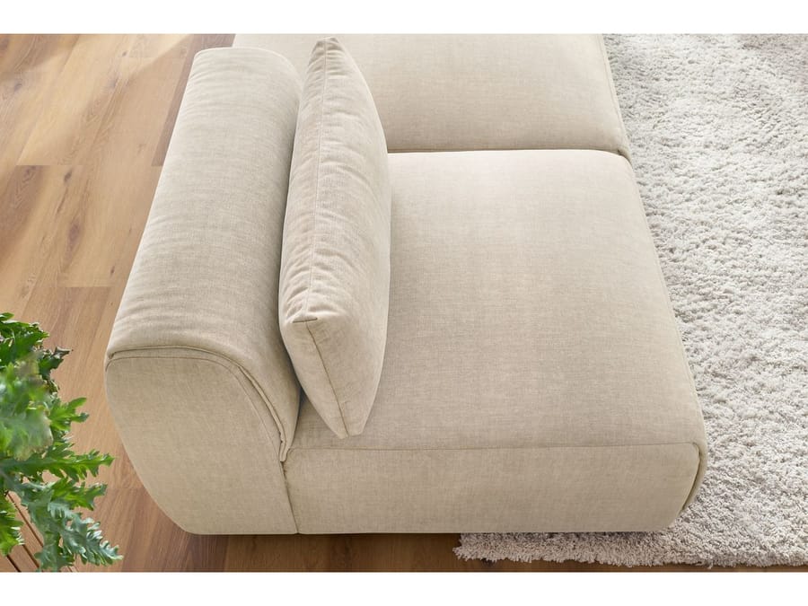 Gros plan accoudoir arrondi et coussin du canapé Jeanne beige tissu