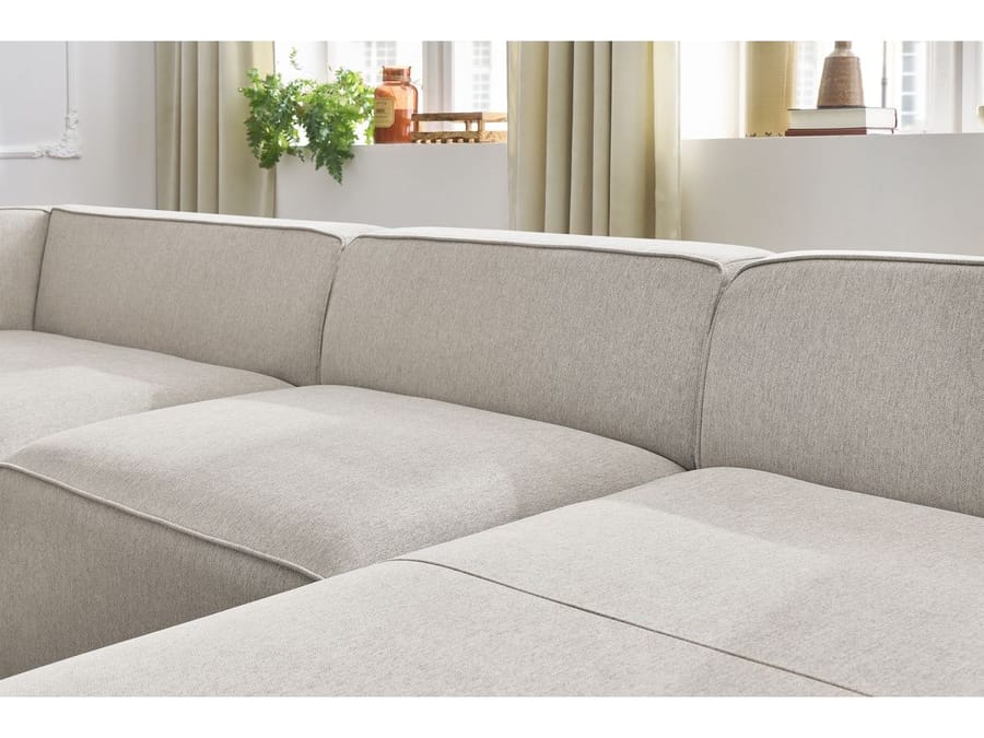 Détail des accoudoirs et des coussins du canapé Megève en tissu beige