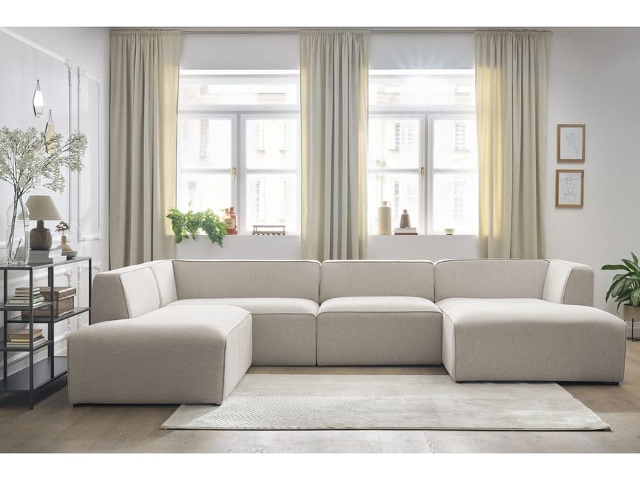 Canapé Megève angle panoramique en tissu beige dans un salon blanc avec fenêtres