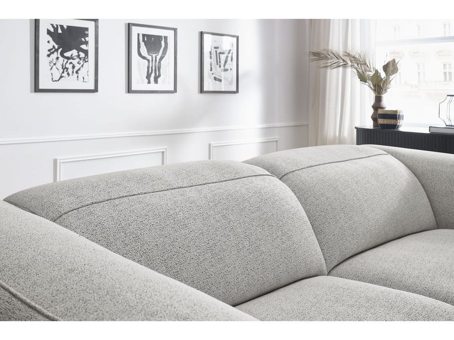 Gros plan sur coussins bombés et coutures du canapé William gris clair
