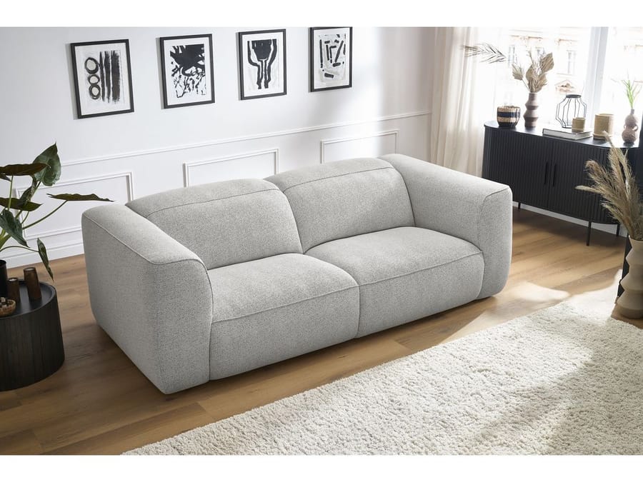 Canapé William gris clair dans salon blanc avec meuble noir et décoration épurée