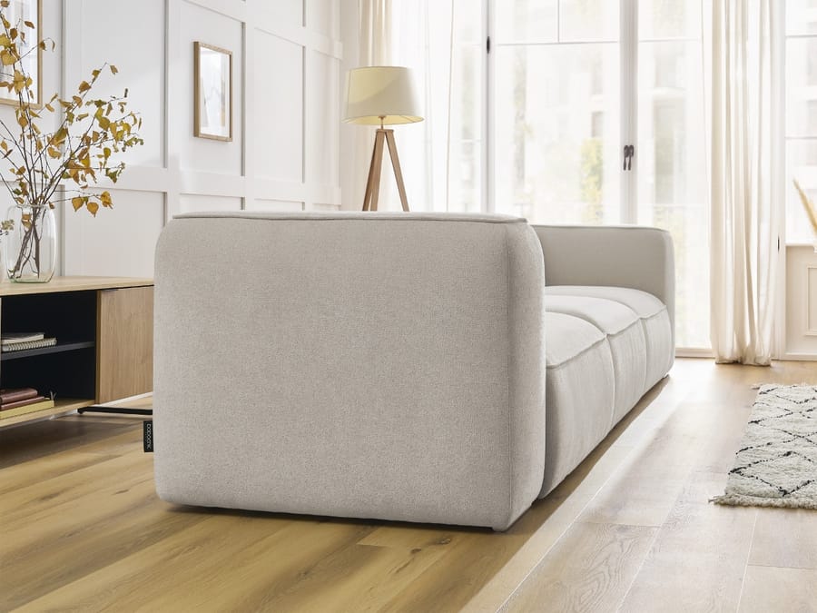Canapé Zephyr en tissu beige clair vu de côté, montrant sa structure modulaire et ses lignes.