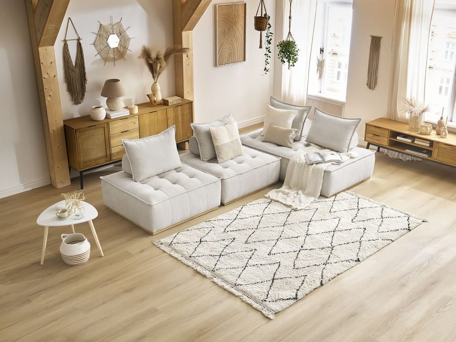 Canapé Elisa blanc modulable dans salon avec mobilier bois clair et décor épuré.