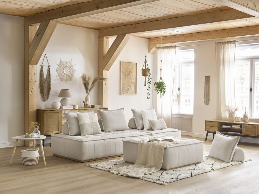 Canapé Elisa blanc en L avec modules arrangés, intérieur scandinave avec poutres bois.