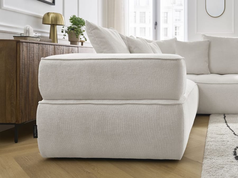 Gros plan sur l'accoudoir et la base du canapé Whesley en tissu beige clair