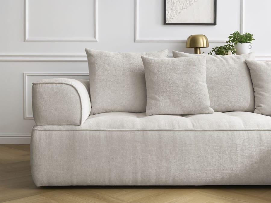 Canapé Whesley en tissu beige vue de côté, accoudoir et coussins décorés visibles