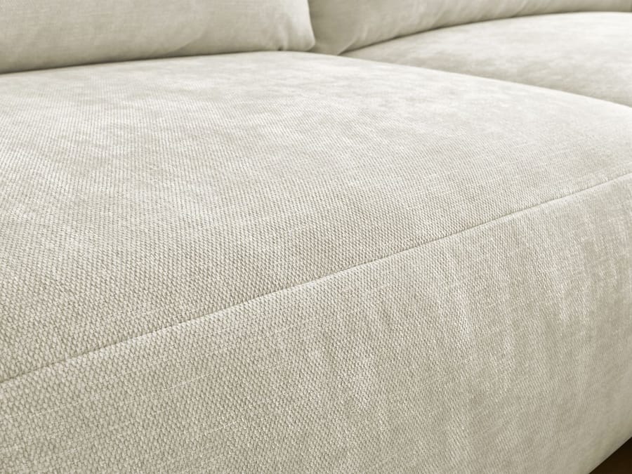 Gros plan du revêtement en tissu beige texturé du canapé Aden montrant l'assise