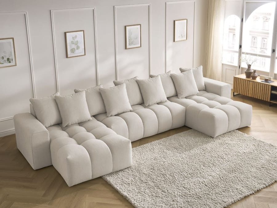 Canapé Mont-Blanc d'angle beige avec méridienne, en salon blanc avec tapis gris.