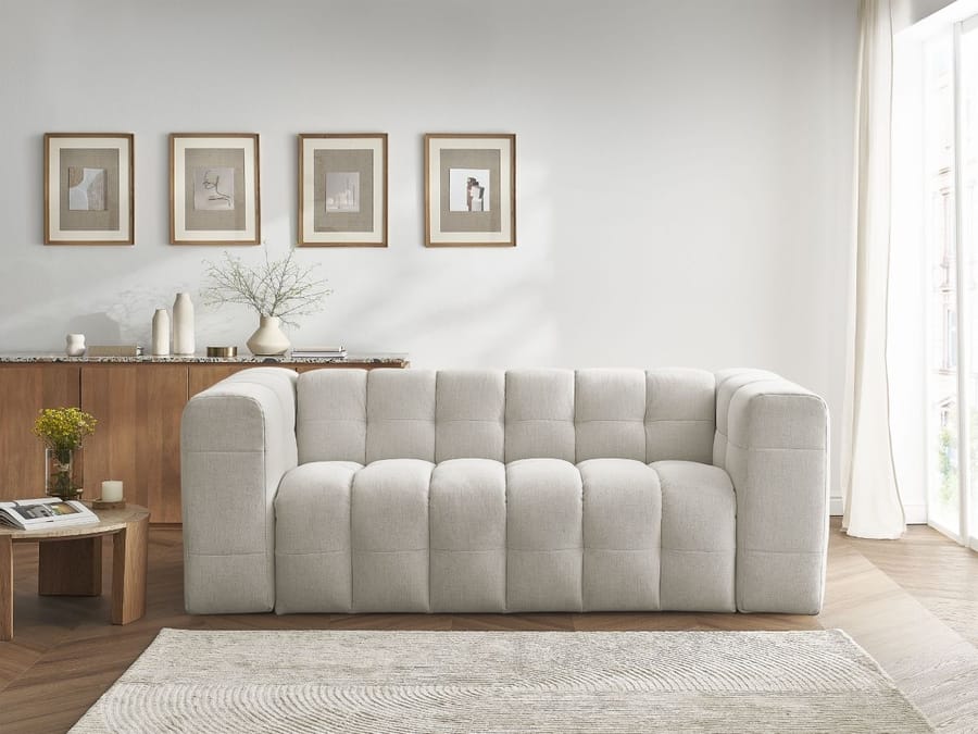 Canapé Cloud beige grand format bombé, face à baie vitrée, cadres muraux, meuble bois