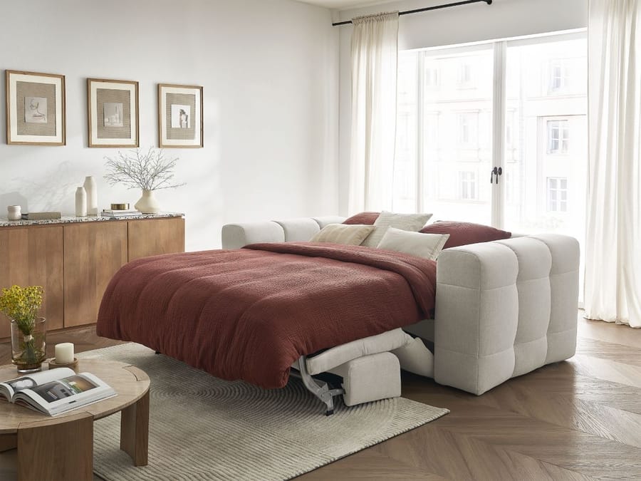 Canapé Cloud convertible lit beige déplié avec matelas blanc visible et couette rouille