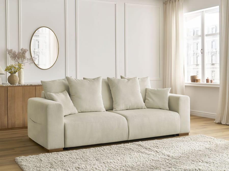 Canapé Sidonie beige dans salon lumineux avec miroir oval et rangement bois