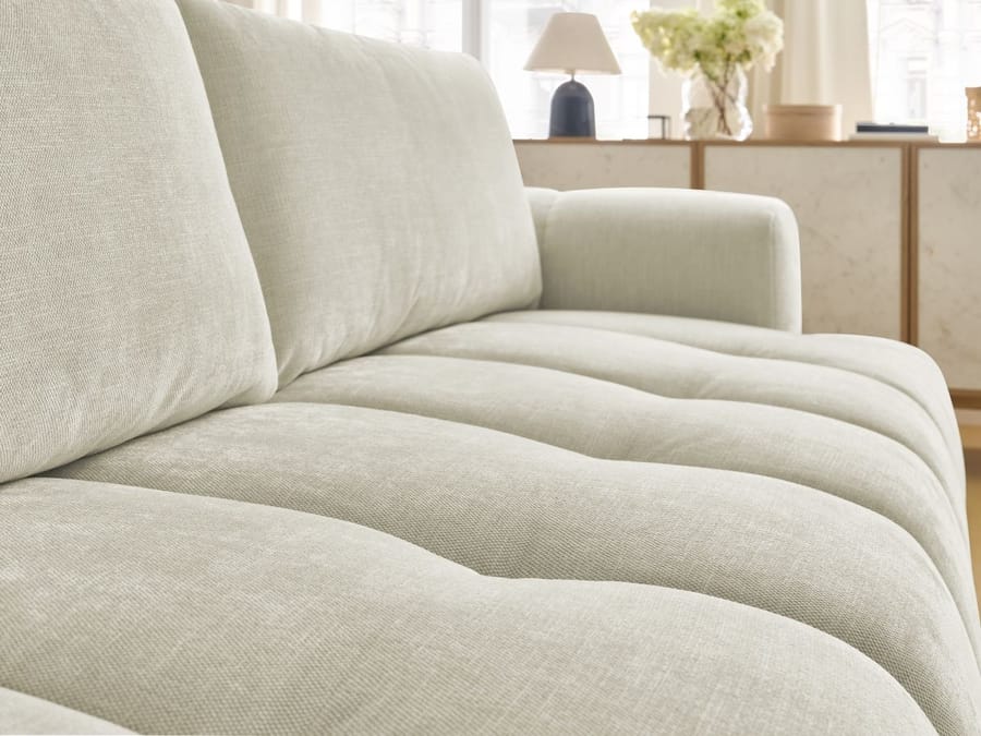 Détail du revêtement en bouclette et des piqûres du canapé Fuji beige.