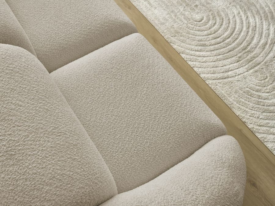 Gros plan de la matière en tissu beige et de la structure du canapé.