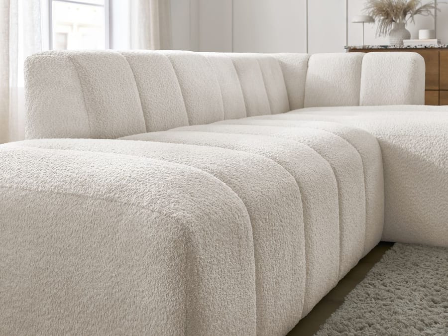 Vue détaillée des coutures et du rembourrage volumineux du canapé Annecy beige