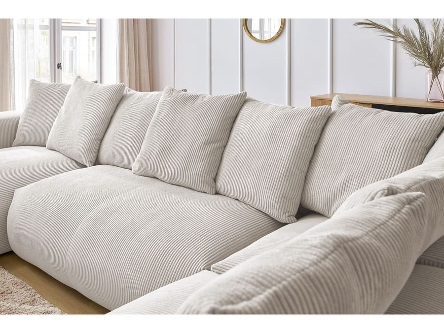 Gros plan des coussins du canapé Voltaire en tissu côtelé beige avec texture très visible