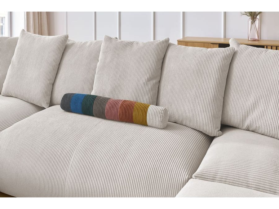 Détail des coussins du canapé Voltaire avec un coussin de couleur rayé multicolore dessus