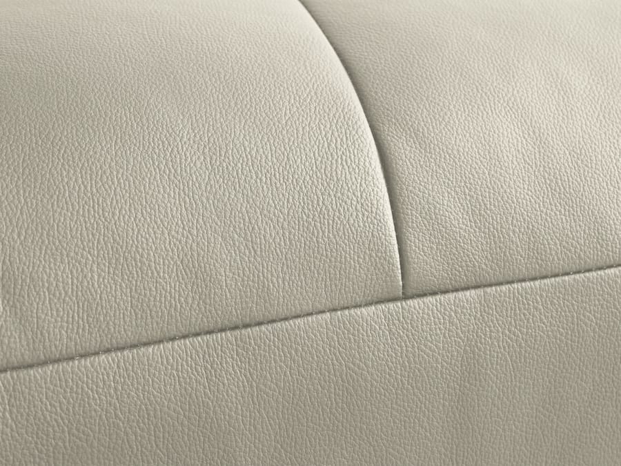 Gros plan du revêtement cuir blanc cassé montrant la texture et les coutures