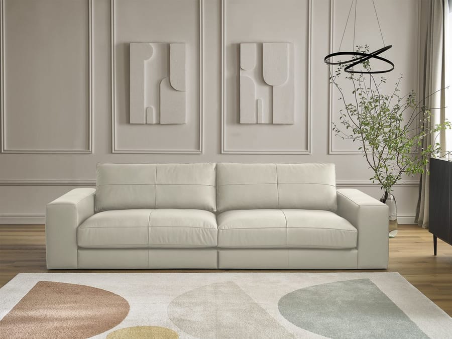 Canapé Leonard blanc cassé dans salon classique avec tableaux et tapis coloré