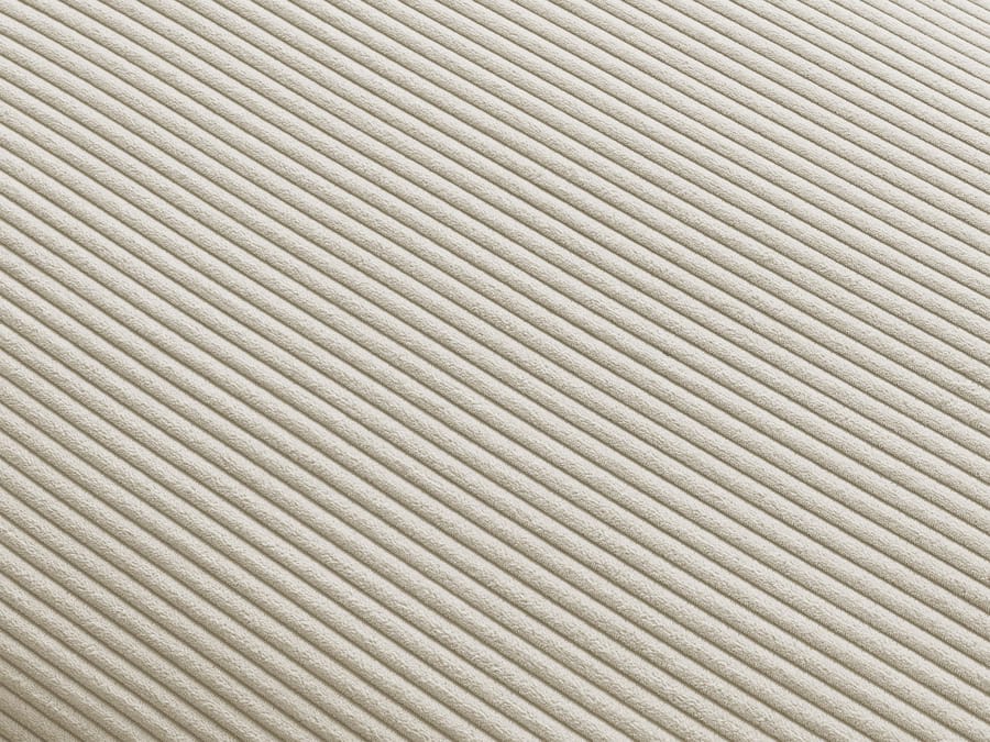 Gros plan du tissu côtelé beige du canapé Paris.