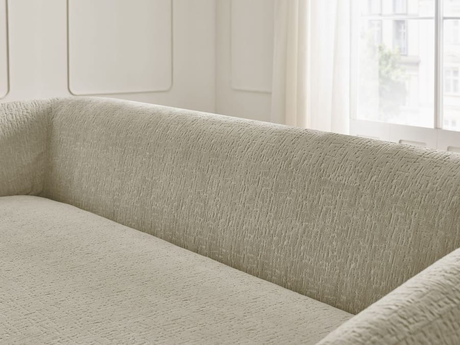Détail du revêtement en tissu beige du canapé Neyo et ses coutures visibles.