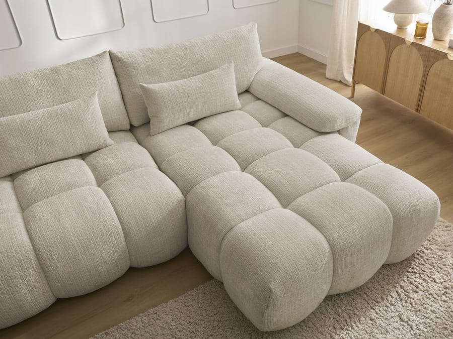 Gros plan des coussins et de la structure gonflée du canapé Ivane beige.