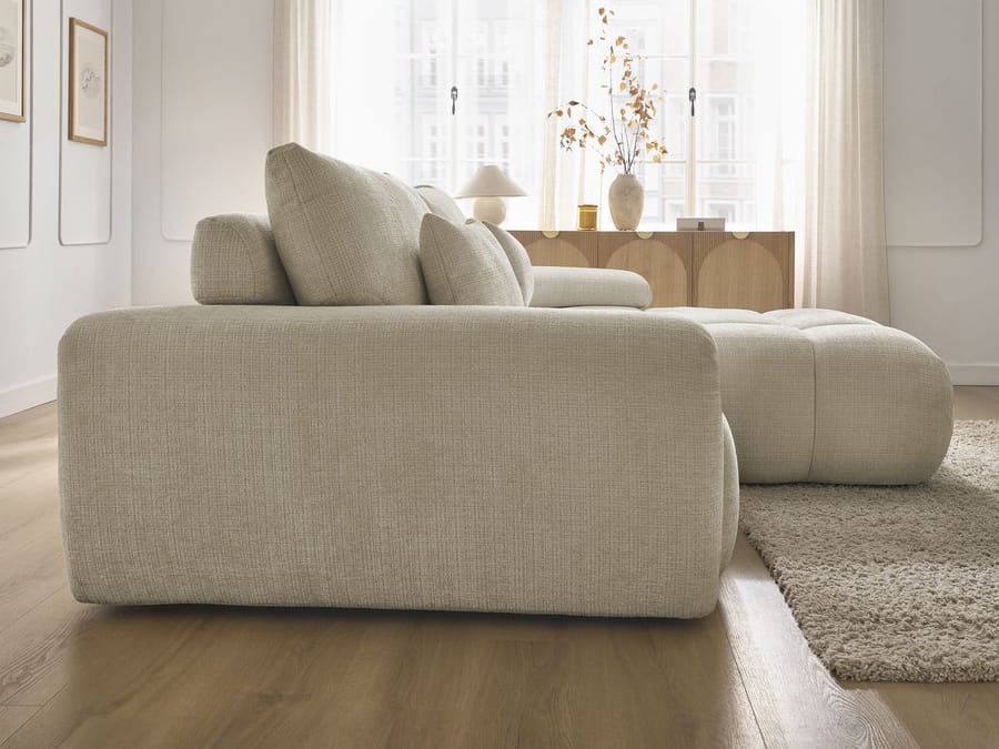 Canapé Ivane d'angle en tissu beige, vue de profil latéral avec accoudoirs visibles.