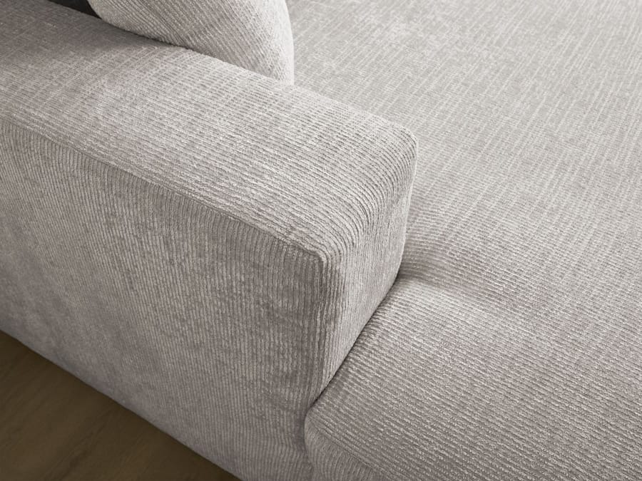 Détail canapé Siméon montrant l'accoudoir et la texture du revêtement gris