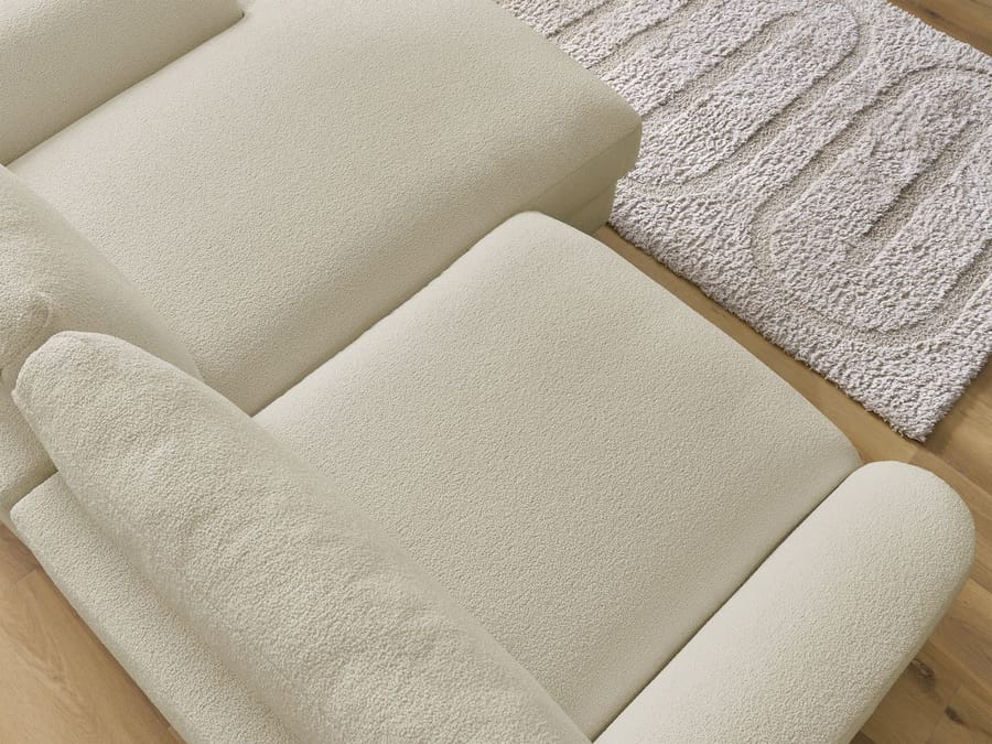 Gros plan des coussins et de l'assise du canapé Léonore en tissu écru