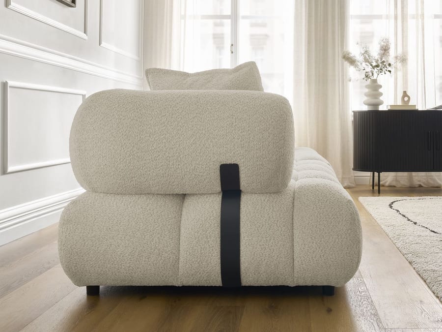Gros plan de l'armature et des coussins arrondis du canapé Alya en tissu beige.