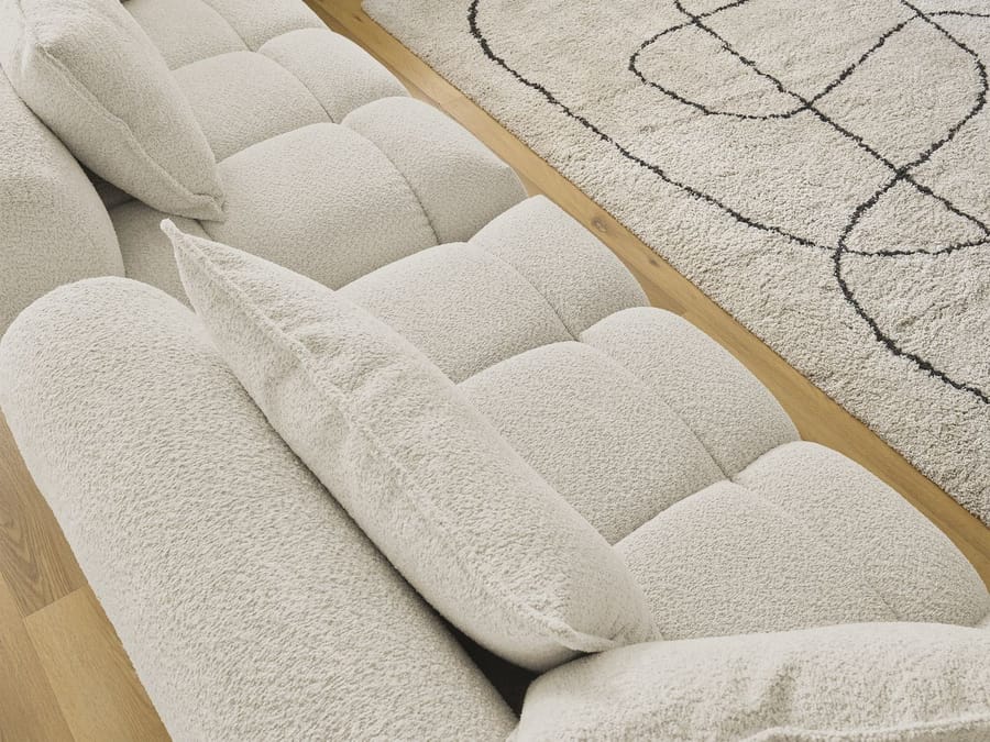 Détail des coussins arrondis et de la matière en tissu épais du canapé Alya.