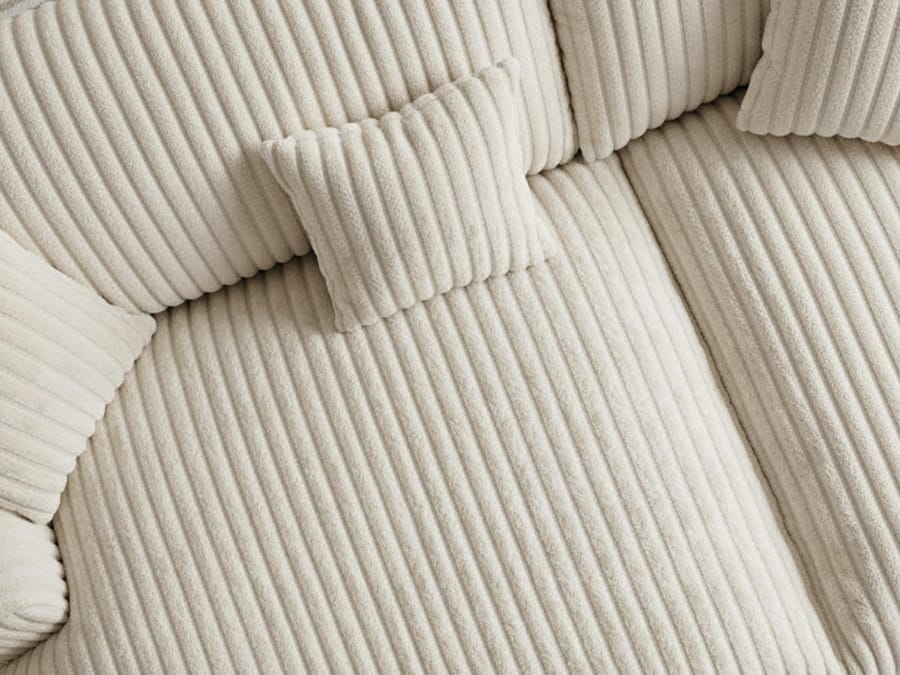 Détail des coussins et de l'assise du canapé Belem en tissu côtelé blanc cassé.