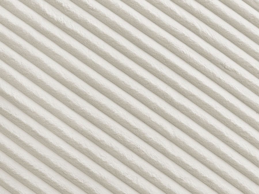 Gros plan de la matière côtelée et du motif de surface du canapé Belem beige.