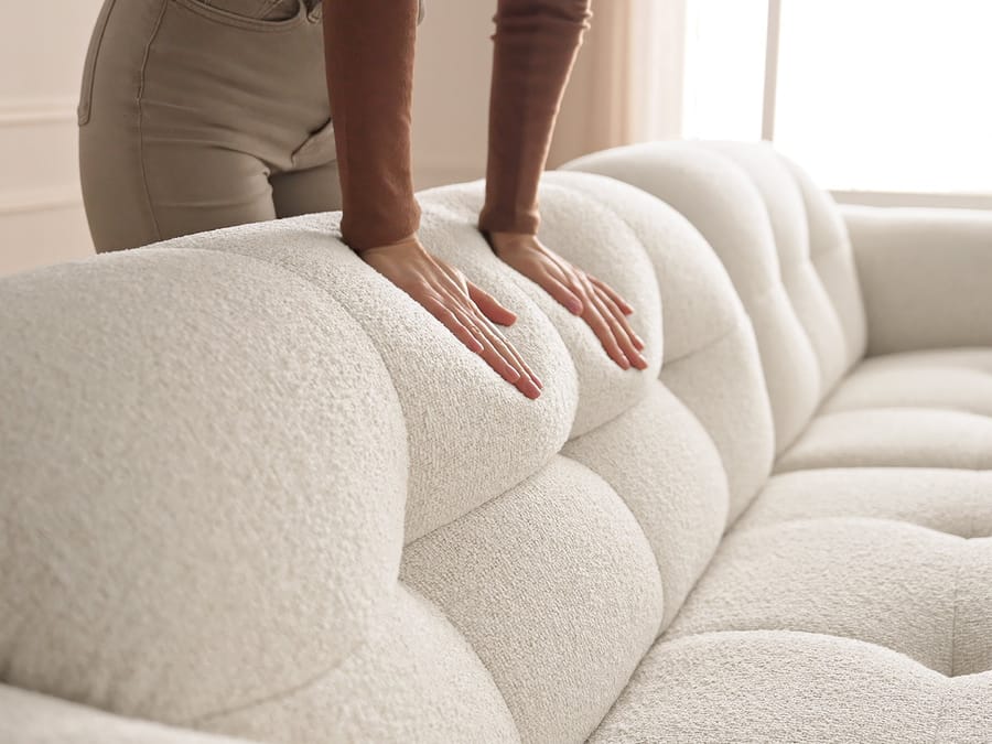 Gros plan sur la texture du tissu beige et les formes molles du canapé Laura.