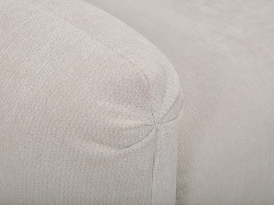 Gros plan sur la texture du tissu beige du canapé Siena et ses coutures.