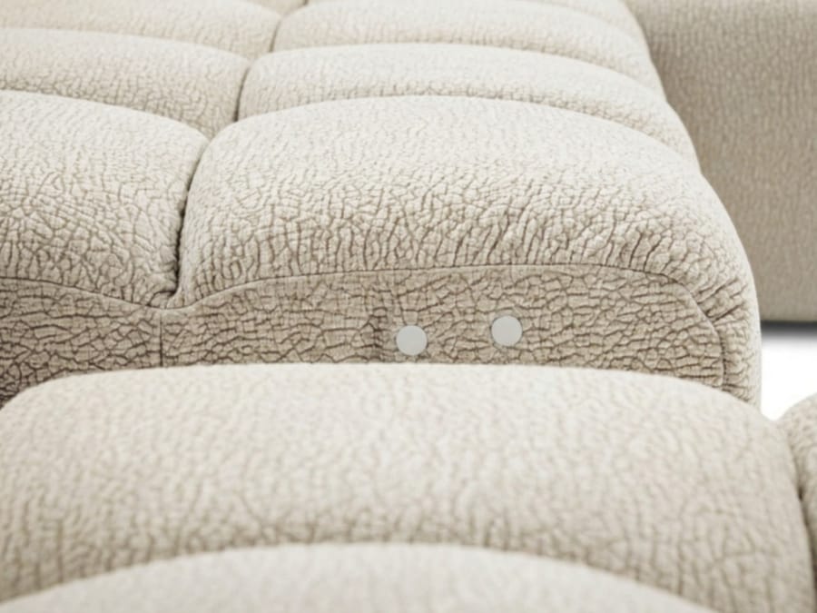 Gros plan détail des coussins quilté beige du canapé André avec texture fine
