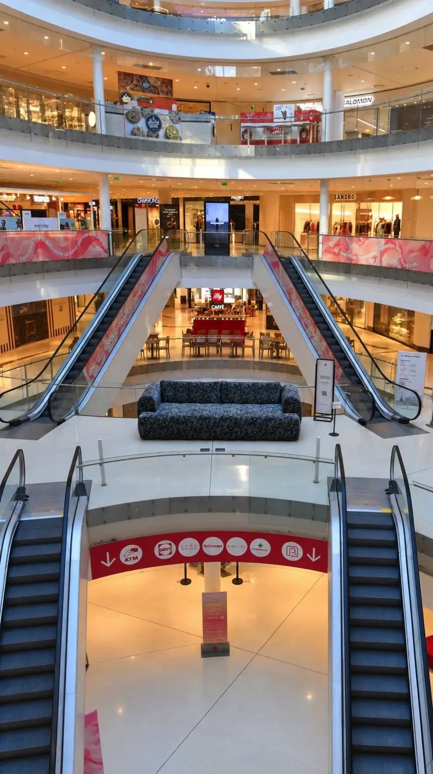Vue plongeante sur les trois niveaux de Beaugrenelle, le canapé Fuji XXL au centre de l'atrium